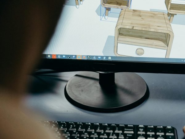 Close-up of digital furniture design on a computer monitor in an office setting.